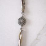 Close-up of Heirloom Tieback featuring neutral ribbons and silver-toned Western concho